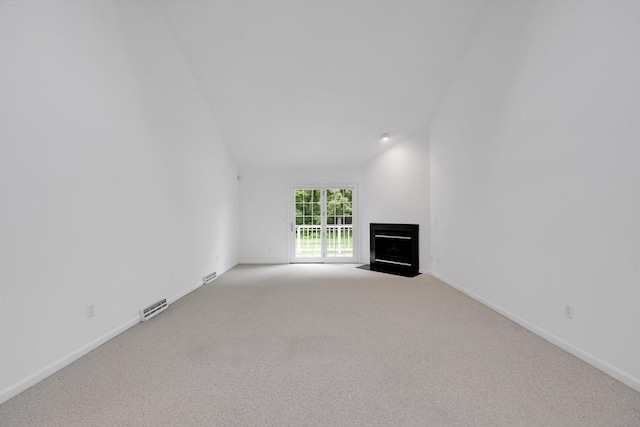 84 Pine Grove Dr Unit 84, South Hadley, MA 01075 - unfurnished living room featuring light colored carpet, a fireplace with flush hearth, and lofted ceiling