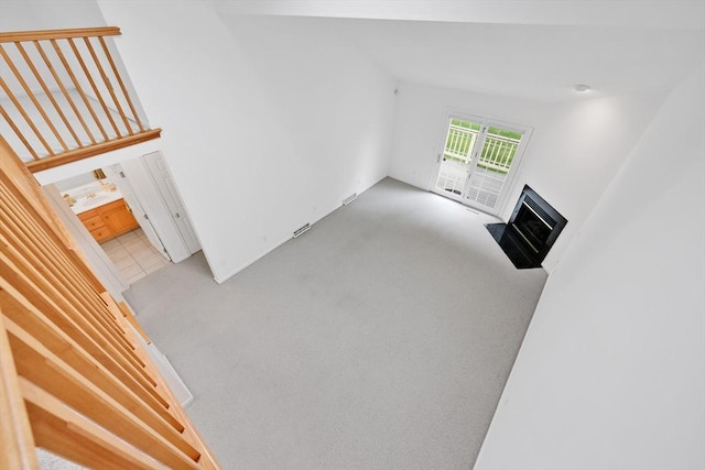 84 Pine Grove Dr Unit 84, South Hadley, MA 01075 - unfurnished living room with light carpet and a fireplace with flush hearth