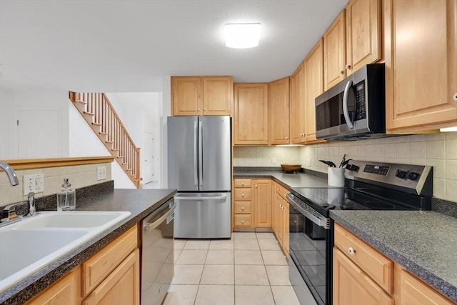 84 Pine Grove Dr Unit 84, South Hadley, MA 01075 - kitchen featuring appliances with stainless steel finishes, dark countertops, decorative backsplash, and light tile patterned flooring
