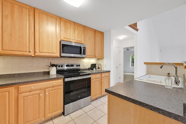 84 Pine Grove Dr Unit 84, South Hadley, MA 01075 - kitchen featuring appliances with stainless steel finishes, dark countertops, light brown cabinetry, and tasteful backsplash
