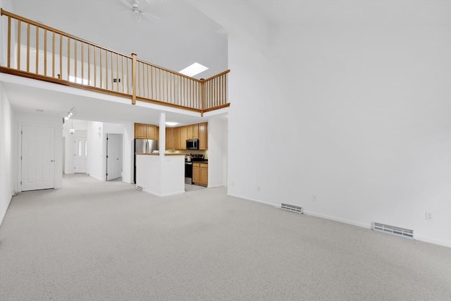 84 Pine Grove Dr Unit 84, South Hadley, MA 01075 - unfurnished living room featuring a towering ceiling, ceiling fan, and light carpet