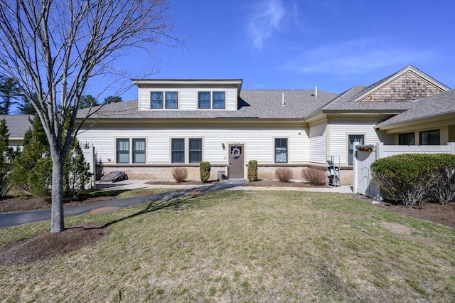 view of front facade with a front lawn and roof with shingles