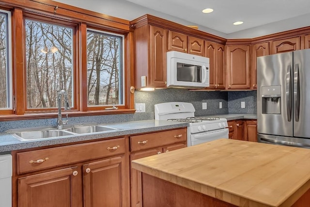 kitchen featuring wooden counters, white appliances, sink, and tasteful backsplash