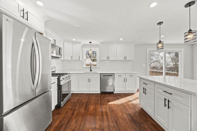 kitchen with white cabinetry, sink, pendant lighting, and stainless steel appliances