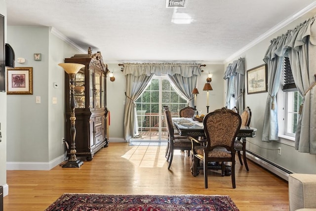 14 Harbor Light Rd, Leominster, MA 01453 - dining space with a baseboard radiator, light wood-type flooring, ornamental molding, and a textured ceiling