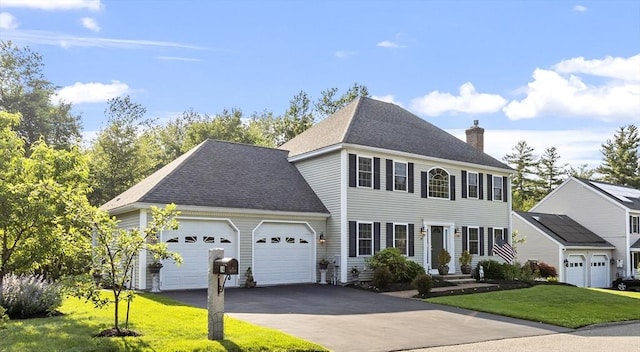 14 Harbor Light Rd, Leominster, MA 01453 - colonial home with a chimney, an attached garage, a front lawn, asphalt driveway, and a shingled roof