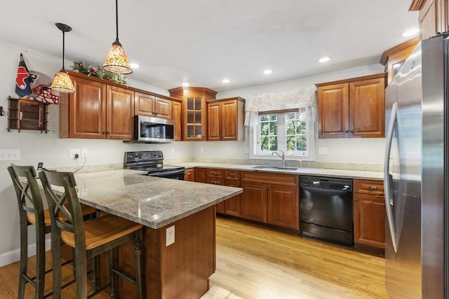 14 Harbor Light Rd, Leominster, MA 01453 - kitchen featuring black appliances, a peninsula, light wood-type flooring, brown cabinetry, and recessed lighting