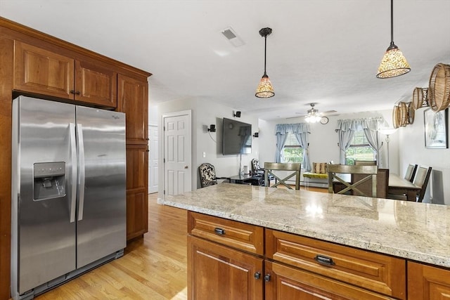 14 Harbor Light Rd, Leominster, MA 01453 - kitchen with stainless steel fridge, light wood finished floors, brown cabinetry, and pendant lighting