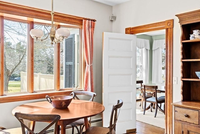 dining room with light wood finished floors and a chandelier