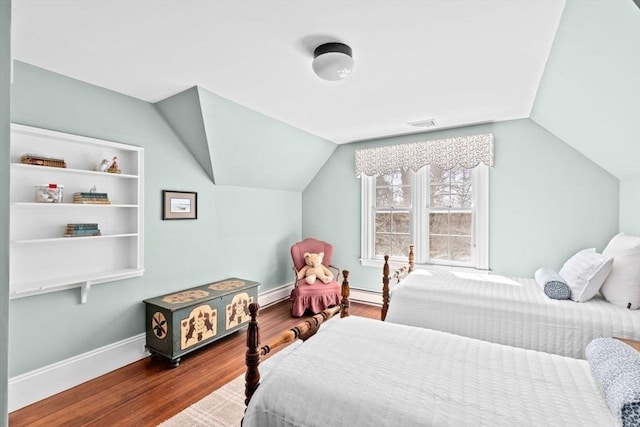 bedroom featuring vaulted ceiling, wood finished floors, a baseboard heating unit, a baseboard radiator, and baseboards