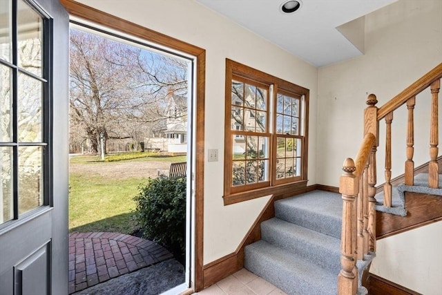 doorway with stairway, baseboards, and light tile patterned floors