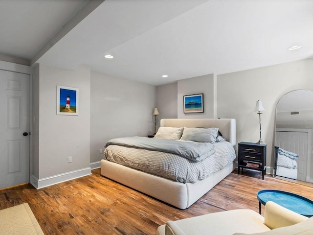 bedroom featuring baseboards, wood finished floors, and recessed lighting