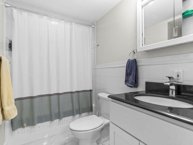 full bathroom featuring tile walls, toilet, vanity, shower / bath combo with shower curtain, and marble look tile flooring