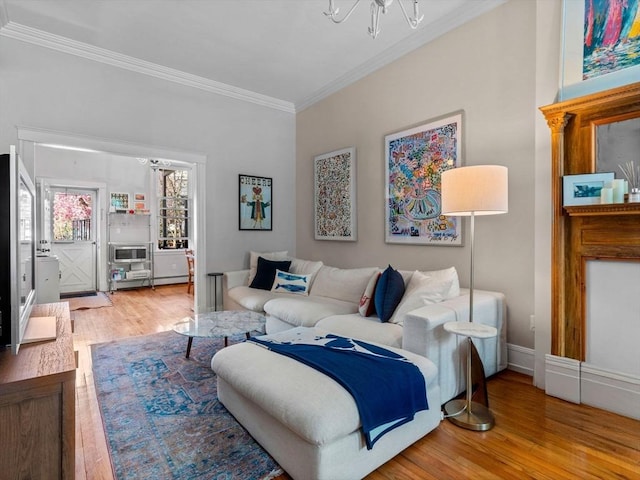 living room featuring crown molding, wood finished floors, and a chandelier