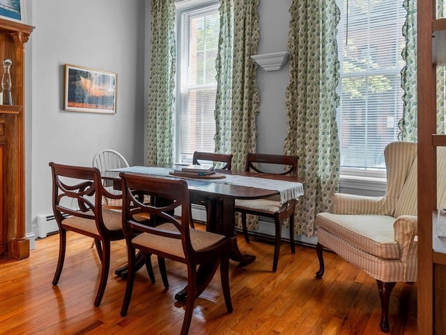 dining space featuring light wood-type flooring and a baseboard heating unit
