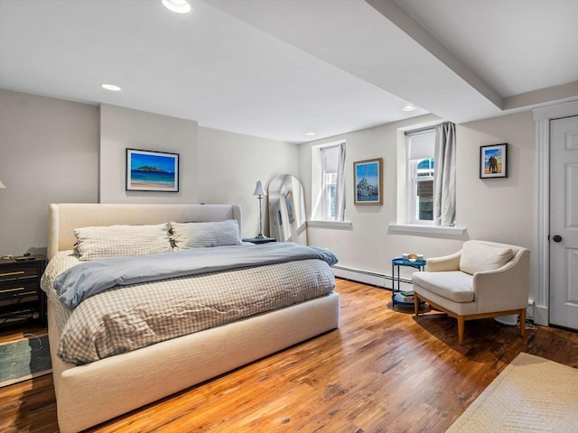 bedroom with a baseboard heating unit, recessed lighting, wood finished floors, and baseboards