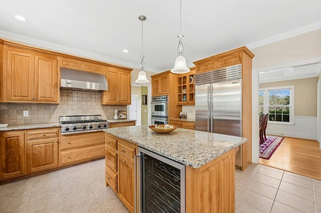 kitchen featuring appliances with stainless steel finishes, ornamental molding, wall chimney exhaust hood, and wine cooler