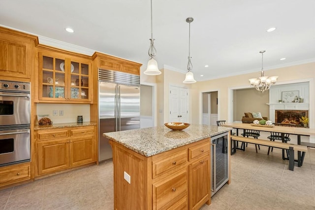 kitchen with crown molding, beverage cooler, stainless steel appliances, a kitchen island, and glass insert cabinets