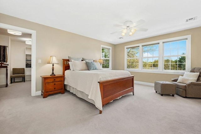bedroom with a ceiling fan, baseboards, visible vents, and light carpet