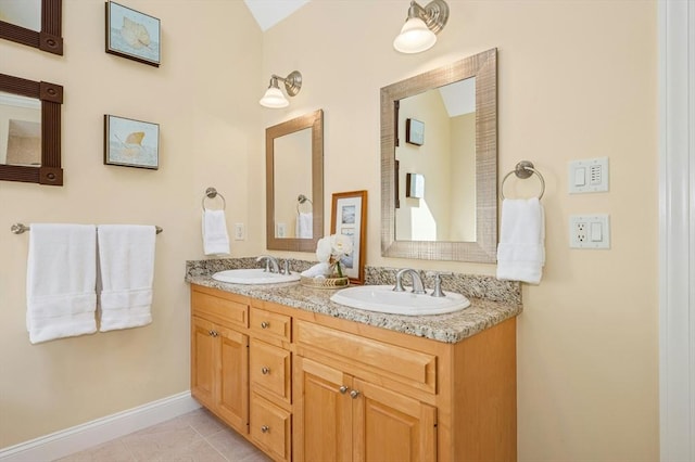 full bathroom with double vanity, a sink, baseboards, and tile patterned flooring