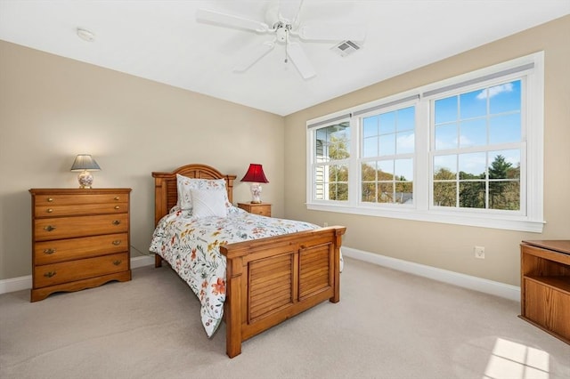 bedroom with baseboards, light colored carpet, ceiling fan, and visible vents