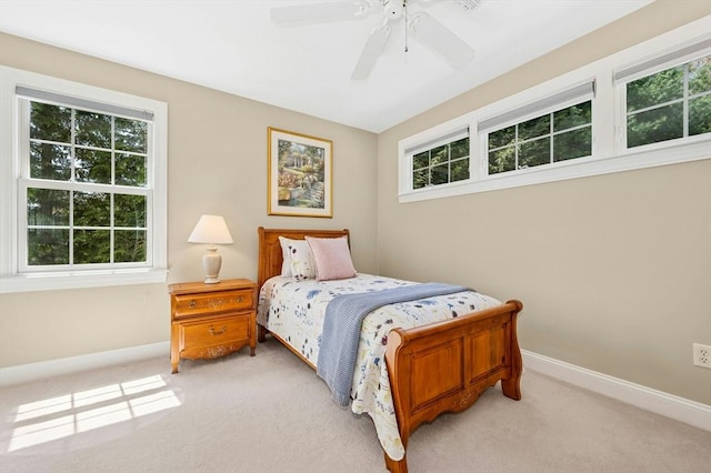 bedroom featuring baseboards, multiple windows, and light colored carpet