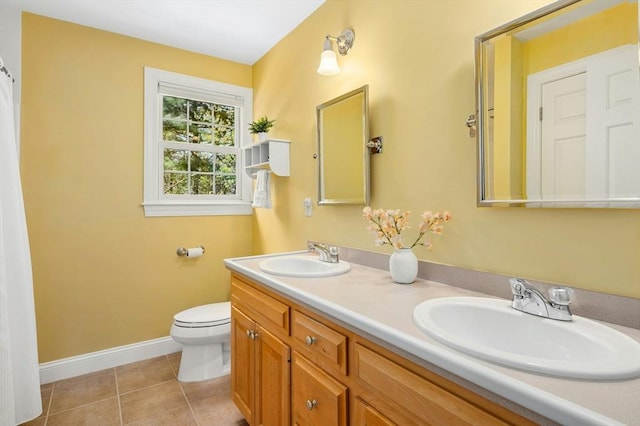 bathroom with baseboards, toilet, tile patterned floors, and a sink