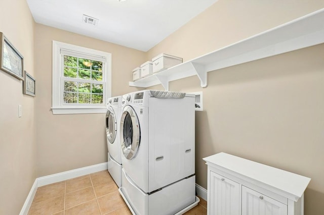 laundry room featuring laundry area, visible vents, baseboards, light tile patterned flooring, and washer and dryer