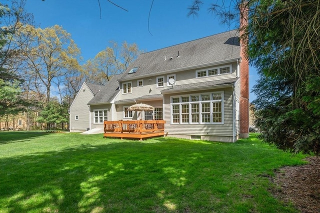 rear view of property featuring a lawn, a chimney, and a deck