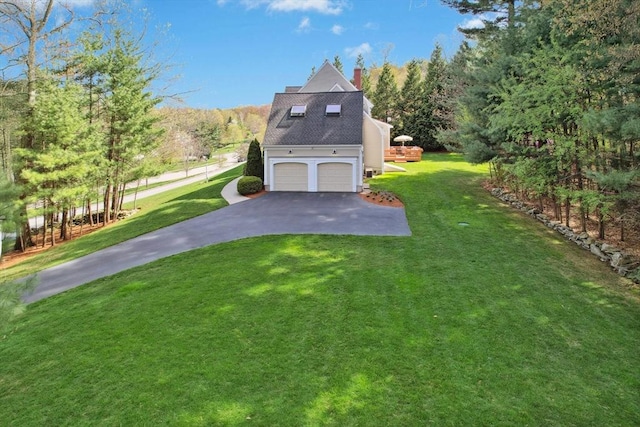 view of home's exterior with a lawn, driveway, a chimney, and a garage
