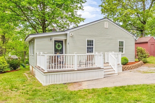 back of property featuring a wooden deck and a yard