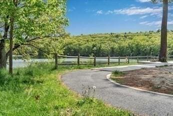 view of home's community featuring fence and a wooded view