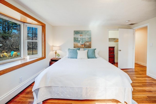 bedroom featuring visible vents, baseboards, and wood finished floors