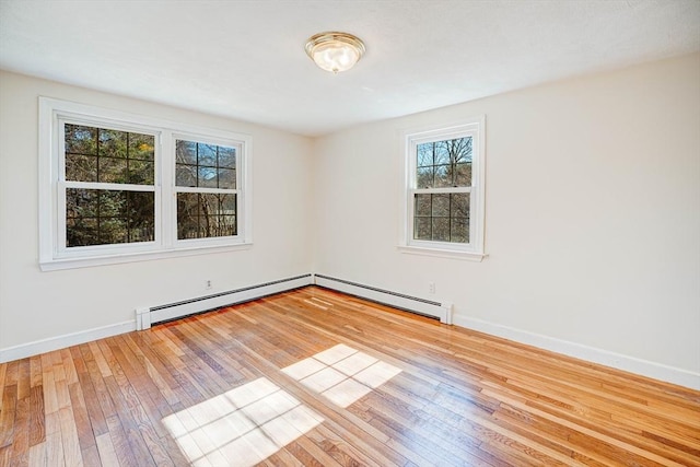 unfurnished room with baseboards, wood-type flooring, and baseboard heating