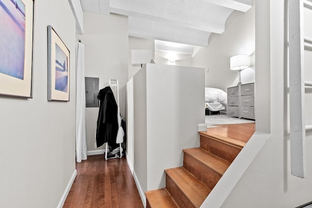 hall with beam ceiling, electric panel, baseboards, and wood finished floors