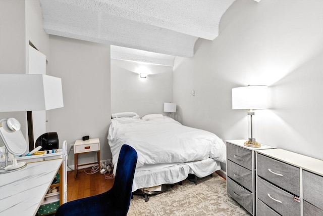 bedroom featuring beam ceiling and wood finished floors