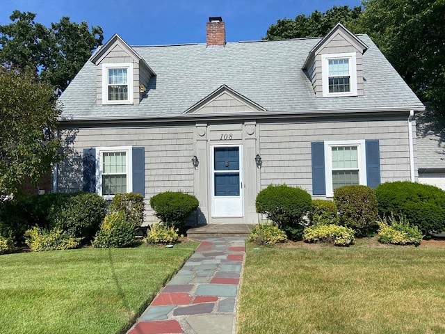 cape cod house featuring a front yard