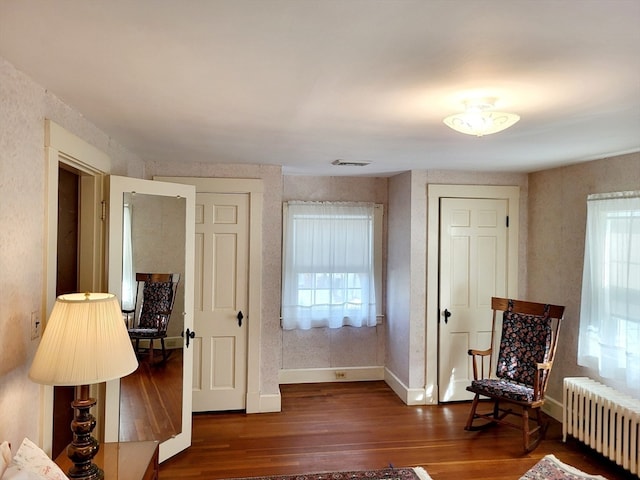 sitting room with dark hardwood / wood-style floors and radiator heating unit
