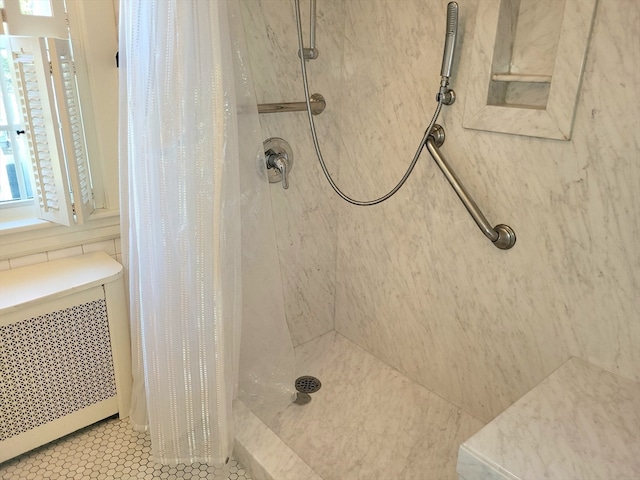 bathroom featuring a shower with curtain, radiator, and tile patterned flooring