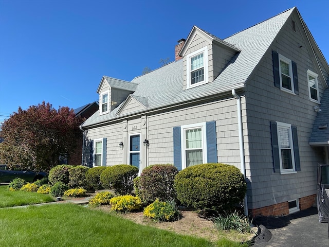 cape cod house with a front yard