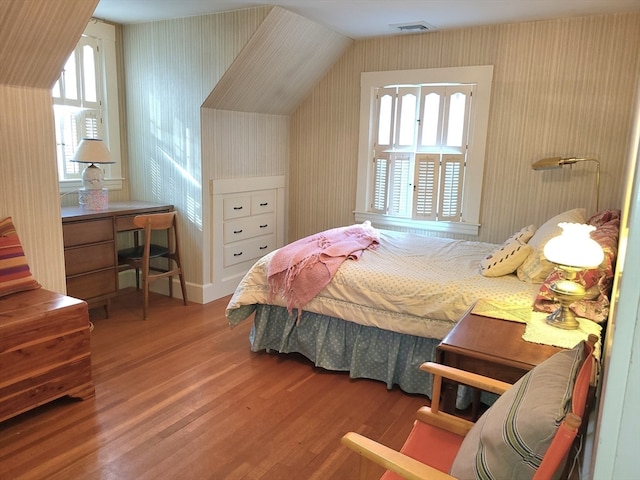 bedroom with lofted ceiling and hardwood / wood-style flooring