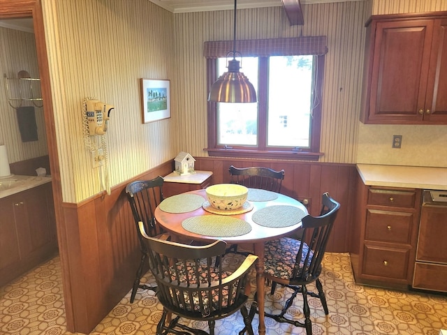 dining space featuring wooden walls and ornamental molding