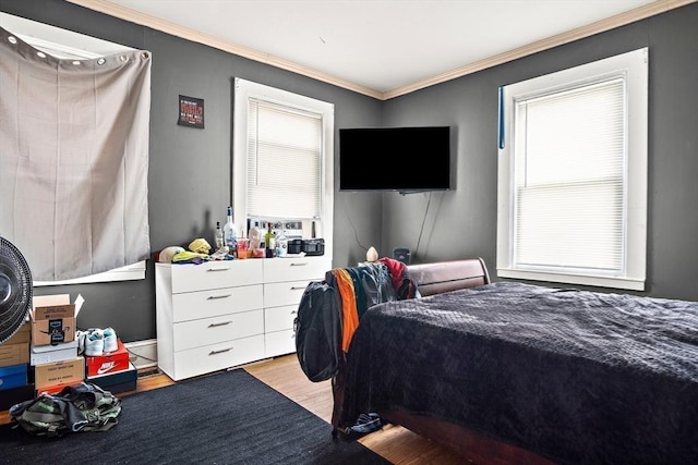 bedroom with light wood-style floors and ornamental molding