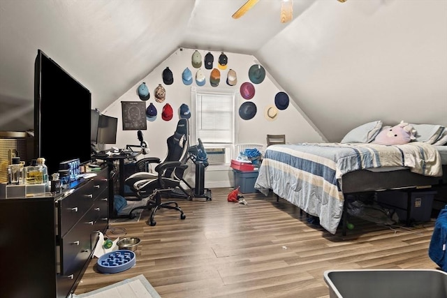 bedroom with ceiling fan, wood finished floors, and lofted ceiling