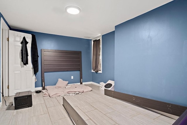 bedroom with baseboards and wood tiled floor