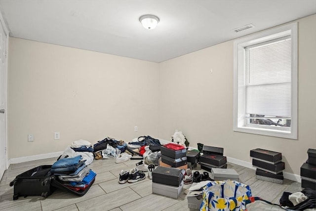 interior space featuring baseboards, visible vents, and wood finished floors