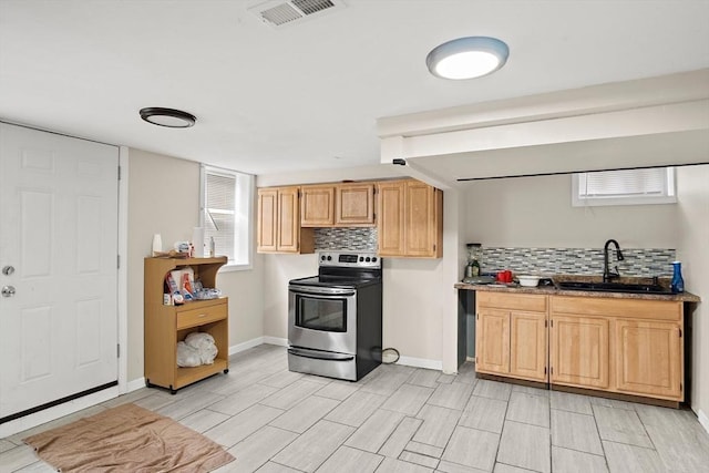 kitchen with stainless steel electric range oven, a sink, baseboards, tasteful backsplash, and visible vents