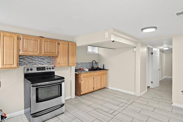kitchen featuring backsplash, a sink, baseboards, electric stove, and light brown cabinets