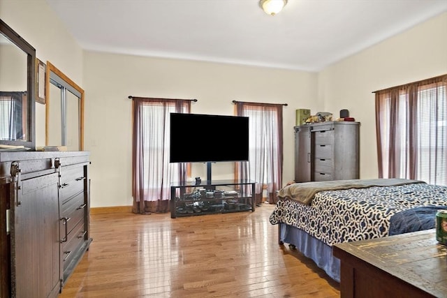 bedroom with baseboards and light wood finished floors