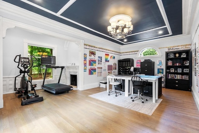 office area with a chandelier, a raised ceiling, and wood finished floors
